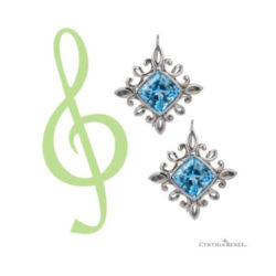 Calligraphy earrings in 18 karat white gold feature a pair of Cambodian blue zircons, weighing a total of 12.20 carats, accented by eight-3.5 mm round tsavorite garnets weighing a total of 1.43 carats.