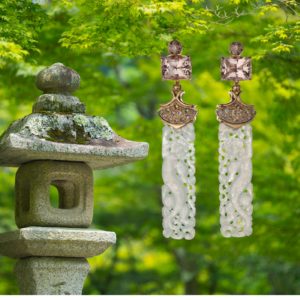 Temple earrings feature naturally colored peach topaz from Pakistan weighing a total of 9.78 carats, along with hand-carved naturally white jade from Burma weighing a total of 36.04 carats. The grey-green sapphires set in 18 karat rose gold weigh a total of 1.02 carats.