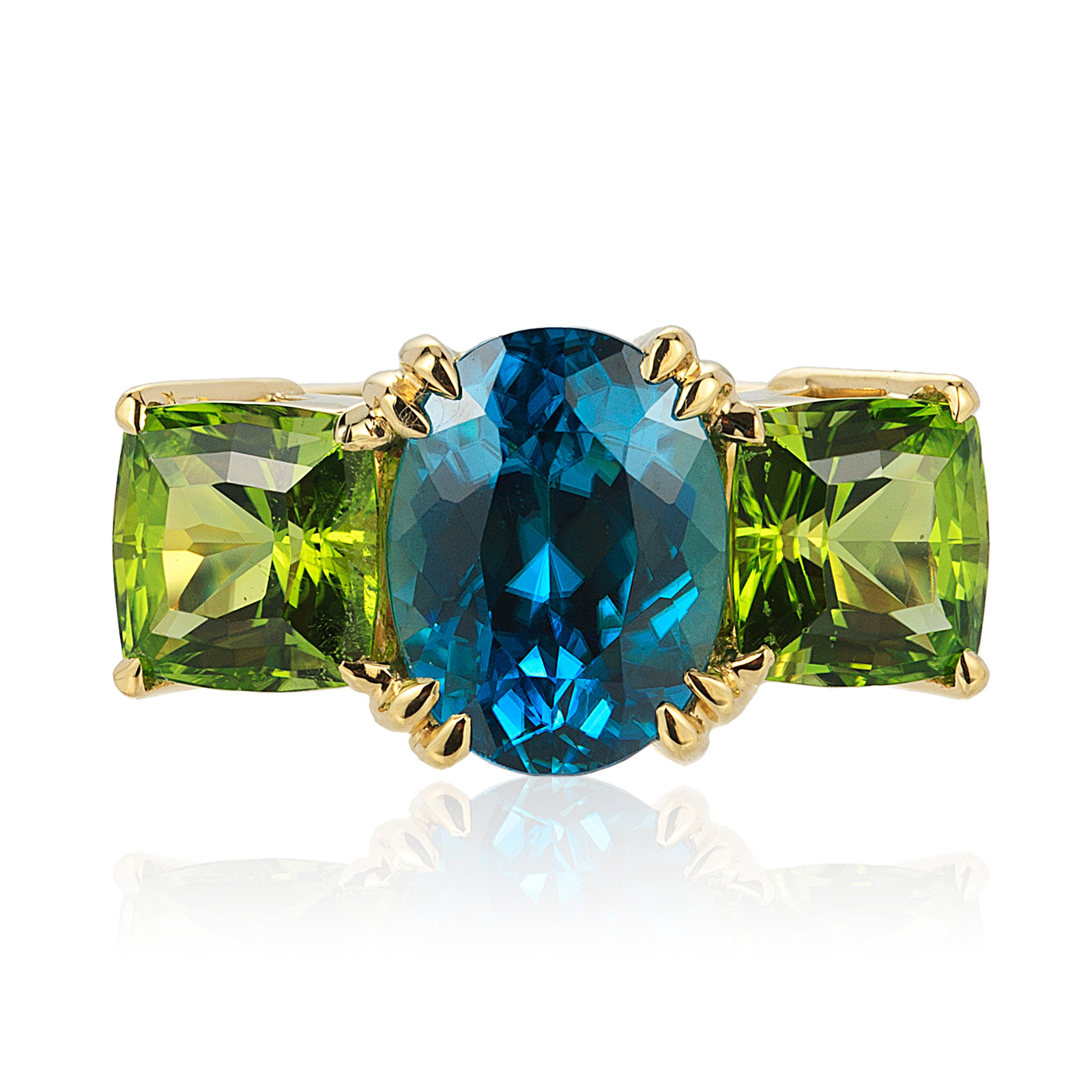 “Heaven & Earth” three-stone ring in 18 karat yellow gold featuring a 5.49 carats vivid Blue Zircon combined with a 4.22 carats pair of Peridot.