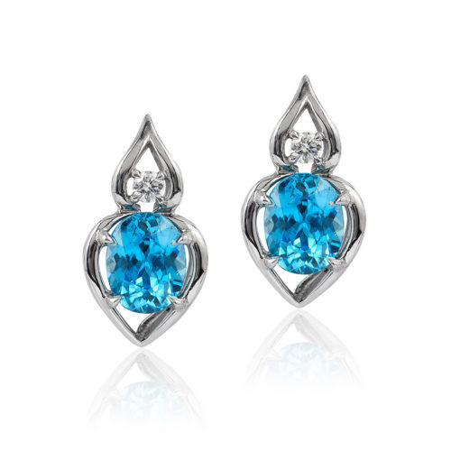 “Pantea” earrings in palladium featuring 5.87 ct. pair vivid Blue Zircon accented by 0.15 cts. fine round diamond; post with friction back. Tail on back support drop.