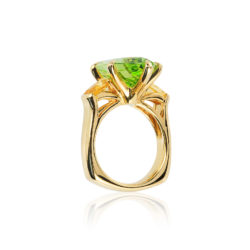 Three-stone ring in 18 kt yg featuring 10.86 ct. designer-cut Peridot accented by 1.29 ct. pair of Yellow Sapphire; size 7, but can size to fit.