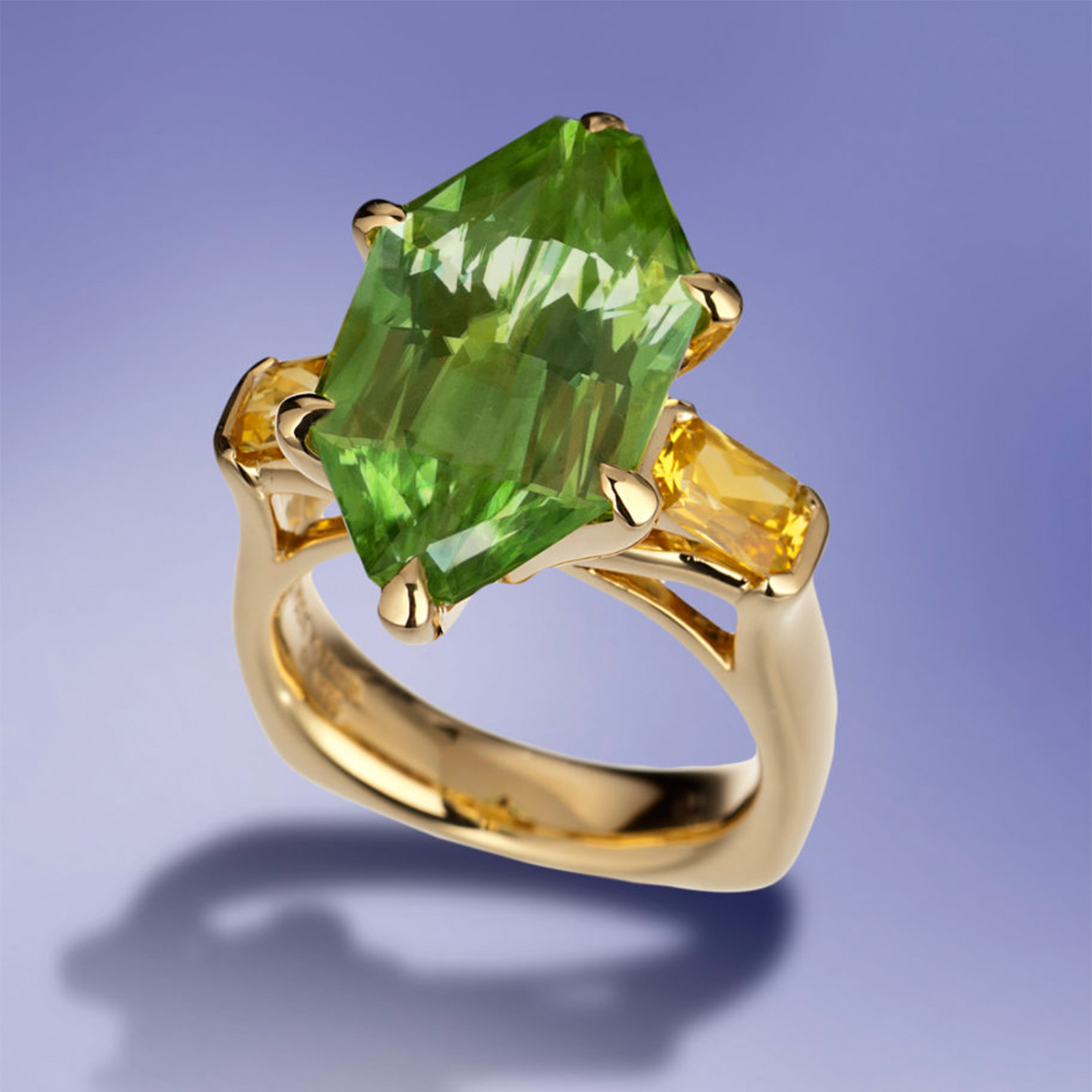 Citrus Dawn Ring, three-stone ring in 18 karat yellow gold featuring 10.86 carats designer-cut Peridot accented by 1.29 carats pair of Yellow Sapphire.
