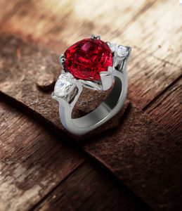 Custom design palladium ring with a 8.93 carat Red Spinel accented by two pear-shaped diamonds weighing 1.23 carats total positioned on a rusted metal band