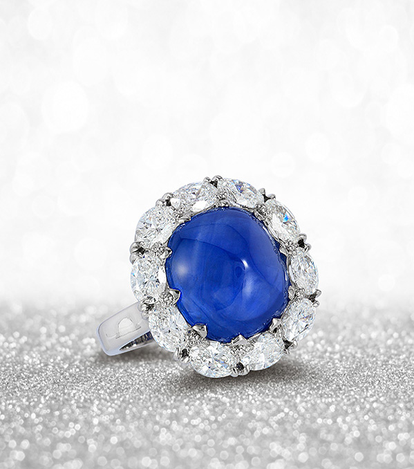 Platinum ring featuring a 12.35 carat blue sapphire, sugar-loaf cabochon surrounded by 2.05 carats of oval diamonds
