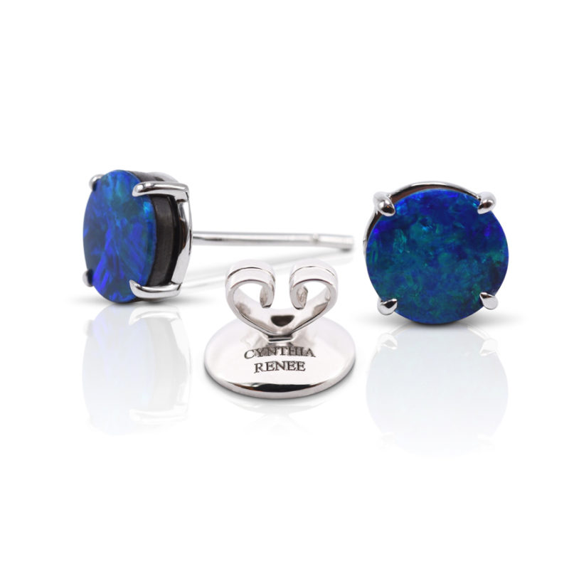 Elegant stud earring in a hand-crafted 18 karat white gold setting featuring pair of 1.89 carats Black Opal doublets; opals measure 7 mm round. 
