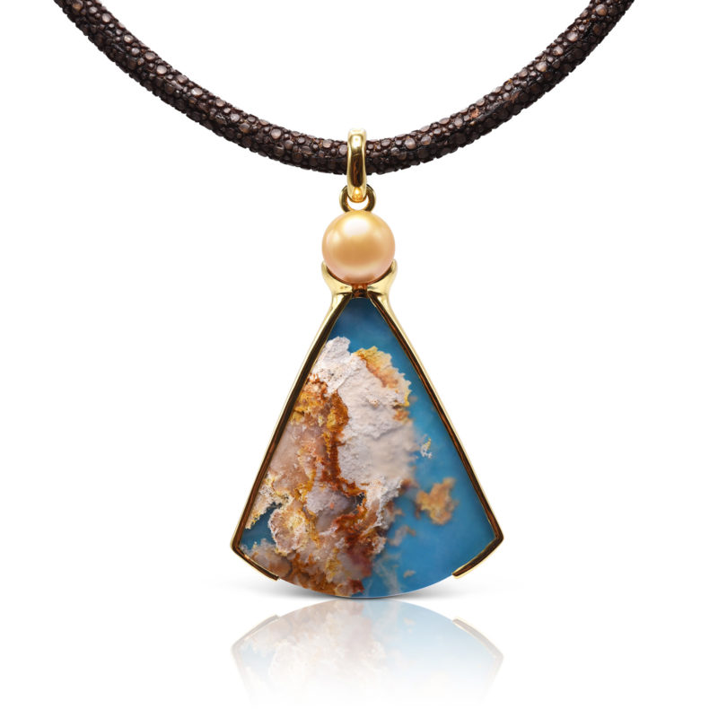 One-of-a-kind pendant crafted in 18 karat yellow gold featuring a 57.65 carat, fan-shaped "Coral Sea Turquoise" accented by a 11.5 mm Golden South Sea Pearl.