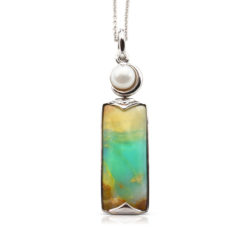 Crescent pendant in 18-karat white gold featuring 8.69 carats natural Opalized Wood and 7-7.5 mm Freshwater Pearl; the opalized wood is found in the West Java Province of Indonesia.