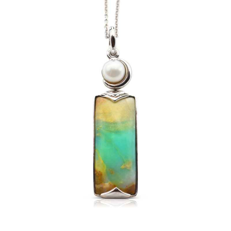 Crescent pendant in 18-karat white gold featuring 8.69 carats natural Opalized Wood and 7-7.5 mm Freshwater Pearl; the opalized wood is found in the West Java Province of Indonesia.