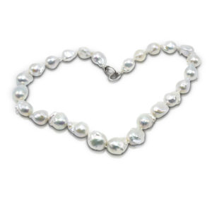 19-inch strand of 25 White Freshwater, Baroque "Fireball" Pearls (N) with each pearl measuring 13 to 16 mm long, strung on knotted thread with a 14 karat white gold triggerless clasp.