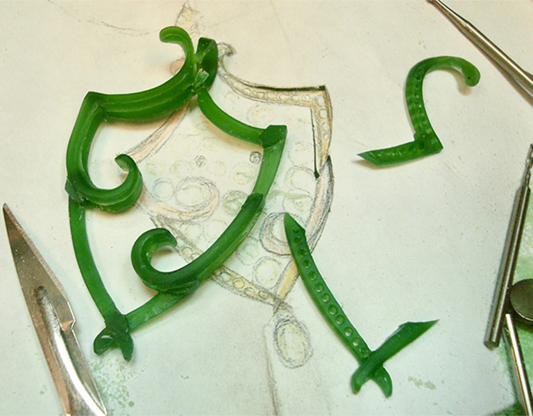 The green wax after carving, along with the sketch of the pendant concept.