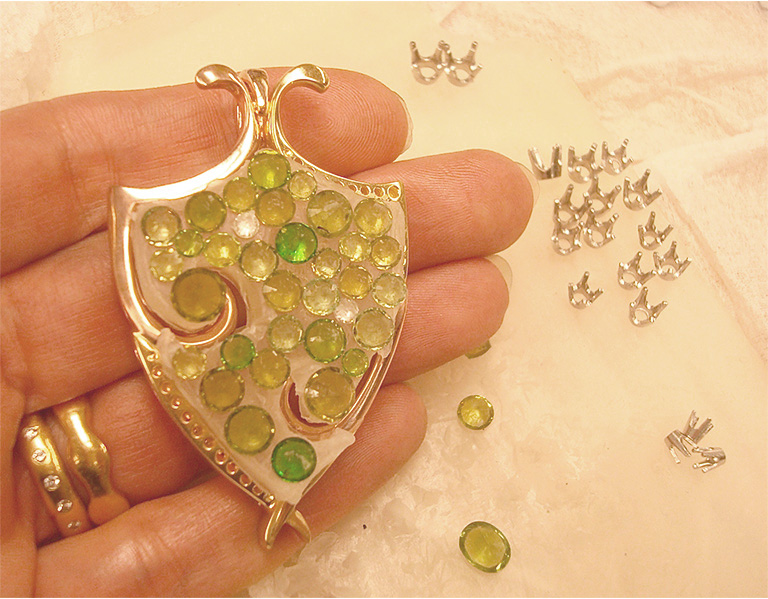 The assembled pendant frame with the demantoid garnets (bottom up) on wax as they would be arranged within the frame. 