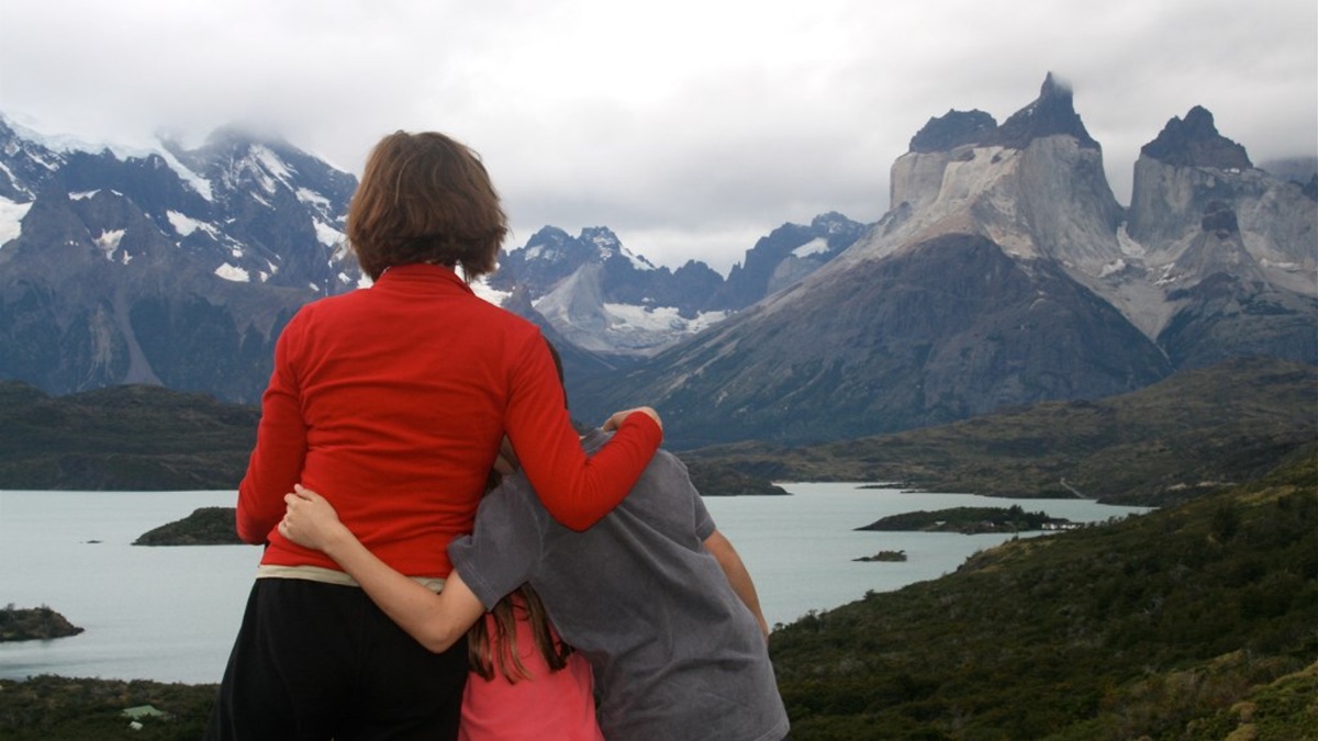 Woman seen from behind embracing a child 