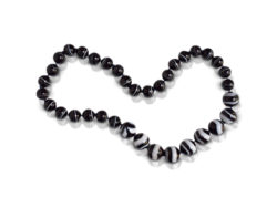 Bead necklace consisting of 35 pieces of natural black and white "Zebra" Sardonyx strung on knotted dark royal blue thread.
