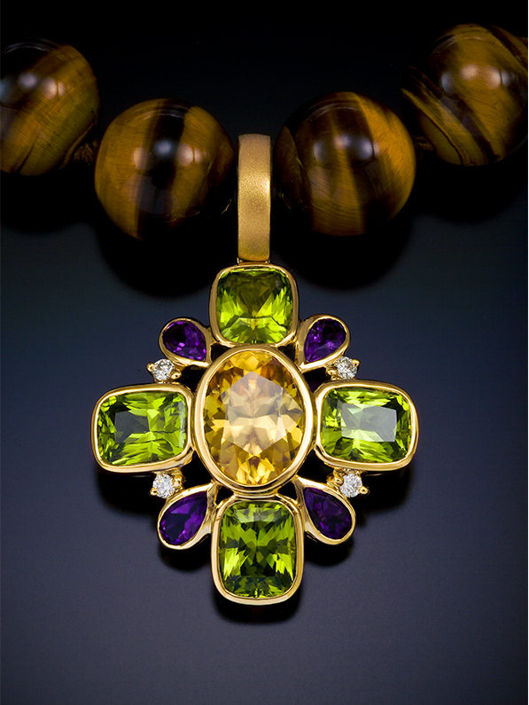 Cynthia Renée Boutique pendant featuring a golden center of Zircon (5.37 carats from Sri Lanka), surrounded by four Peridot (7.17 carats, Pakistan), four Amethyst (0.93 carats from Brazil) and four diamonds (0.12 carats) all set in 18 karat yellow gold.