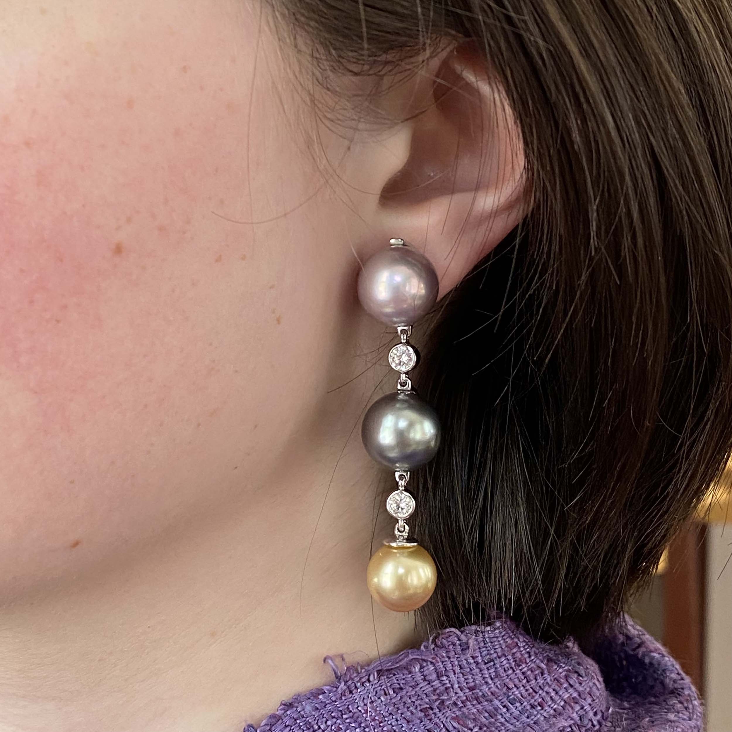 Three 13mm pearls and diamond earrings on a woman's ear
