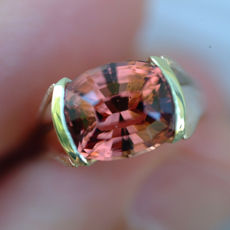The malaia garnet in this ring has a peachy-pink- hue.