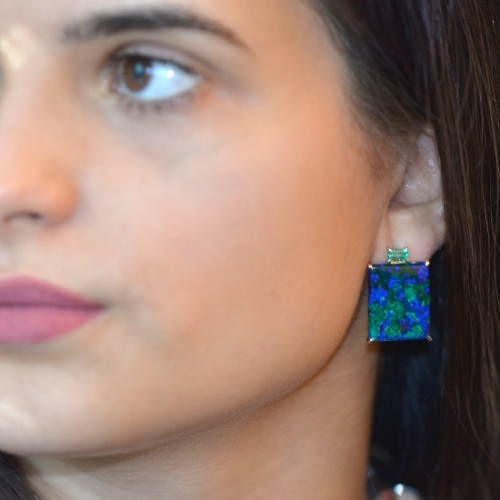 Woman wearing rectangular Azurite and emerald earrings.