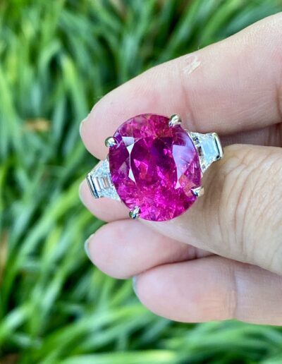 Ring featuring a 14.90 carat hot Red Tourmaline from Cruzeiro, Brazil flanked by 1.59 carats of trapezoid-shaped diamonds, set in 14 kt white gold.