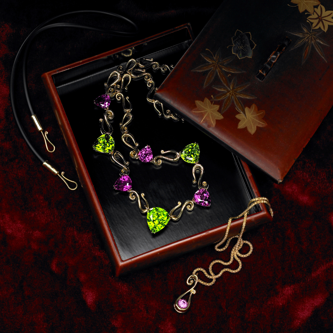 Peridot and Rhodolite garnet necklace in a decorative box on a red cloth