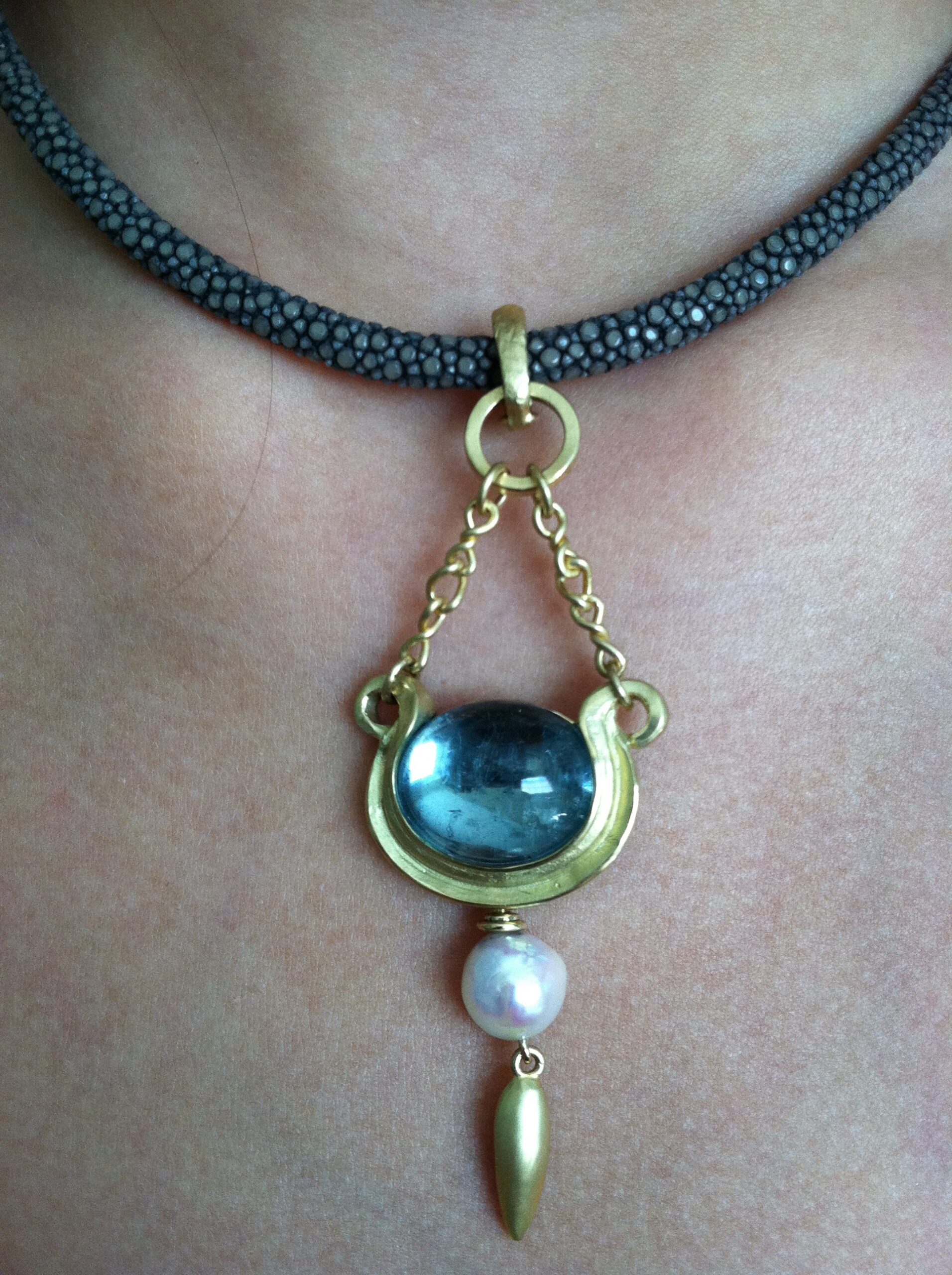 A Cynthia Renee bespoke pendant featuring an aquamarine cabochon, designed with a feeling of antiquity