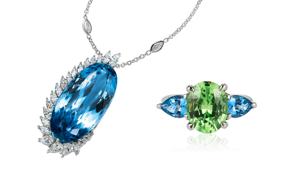 Diamond and aquamarine pendant suspended next to an aquamarine and peridot ring on a white background