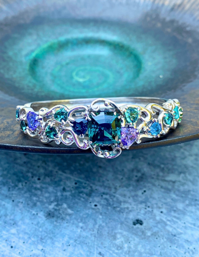 “Mermaid’s Pleasure” ~ Cynthia Renee Bespoke Bracelet featuring a rare teal-green unheated Tanzanite (zoisite) weighing 9.40 carats accented with a variety of Tourmaline (one is a “Paraiba” cuprian Tourmaline) and Tanzanite, all set in 14 karat white gold.