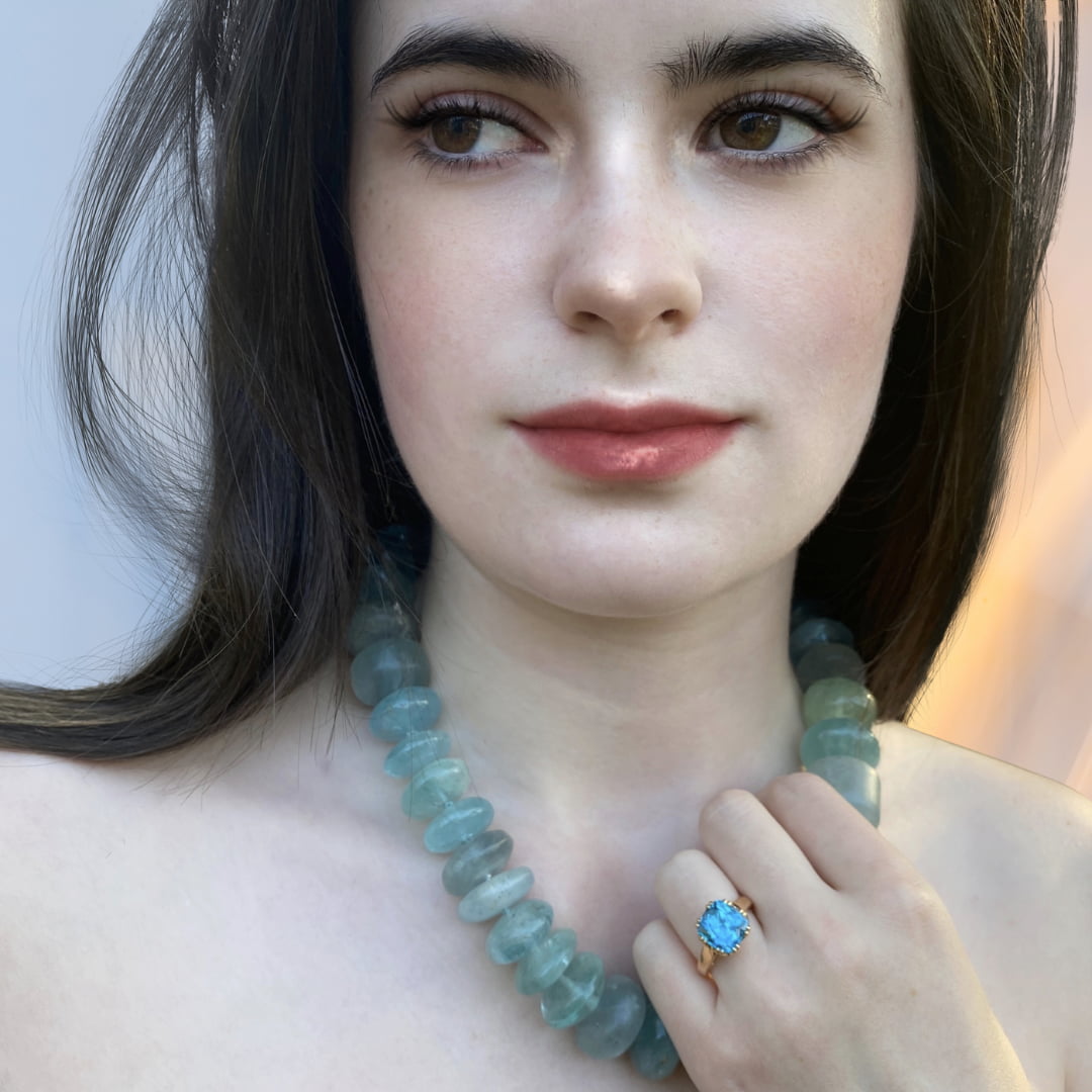 Model wearing necklace and ring, practicing their adornment ritual